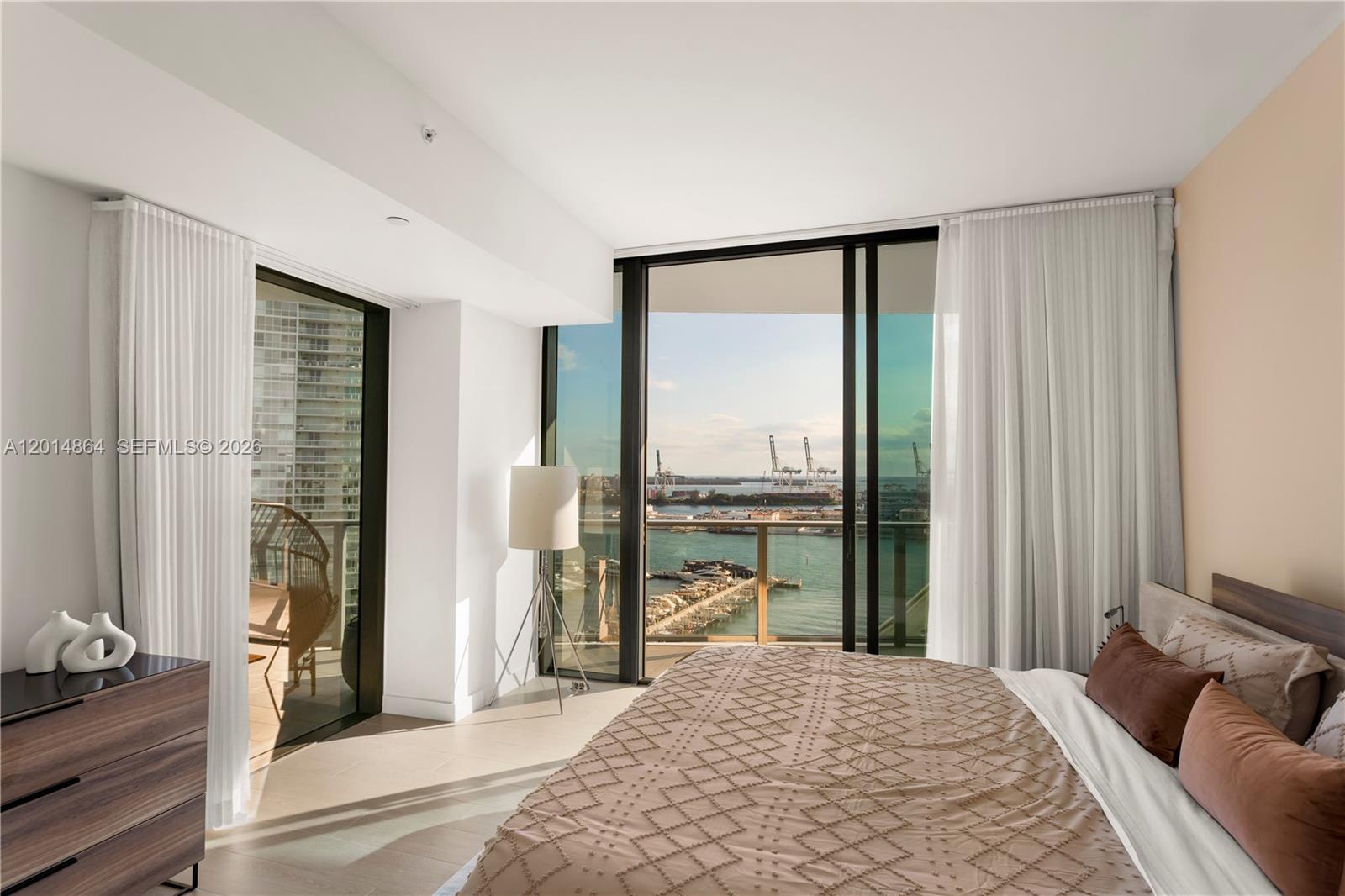 500 Alton Road, Unit 1601 Miami Beach, FL 33139 - Photo 13 of 20 a bedroom with a bed and large windows