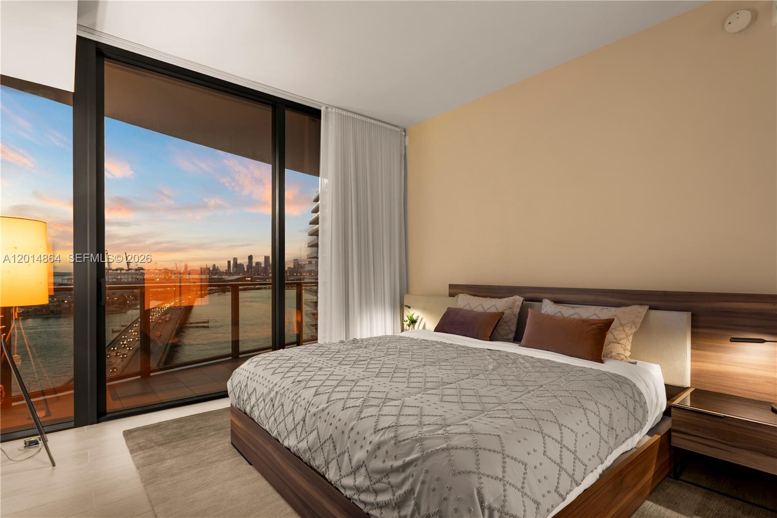 500 Alton Road, Unit 1601 Miami Beach, FL 33139 - Photo 14 of 20 a bedroom with a large bed and a balcony view