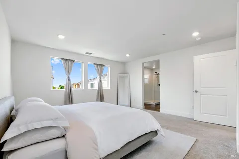 a bedroom with a large bed and a chandelier