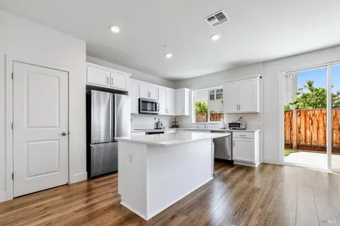 a kitchen with white cabinets and stainless steel appliances