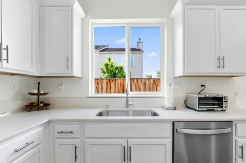a kitchen with white cabinets and a sink