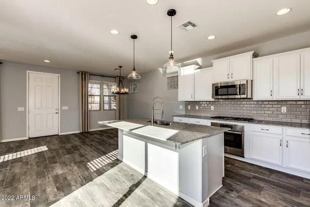 a kitchen with granite countertop stainless steel appliances a stove sink and microwave