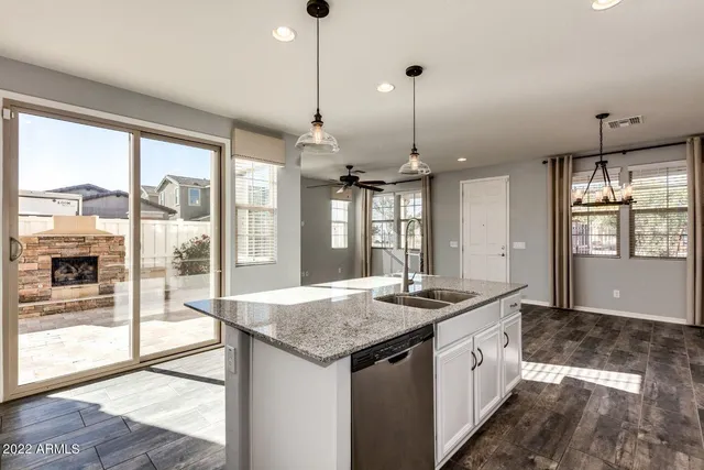 a kitchen that has a sink a counter top space and a view of living room