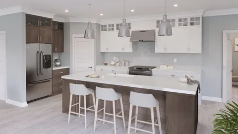 a kitchen with a sink a refrigerator and white cabinets