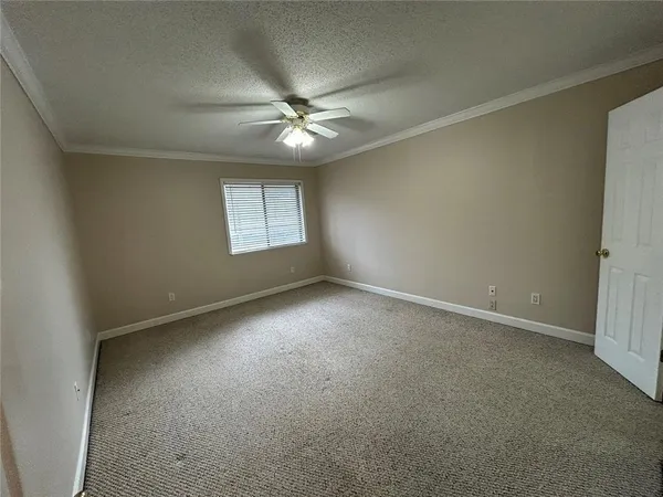 an empty room with a window and a fan
