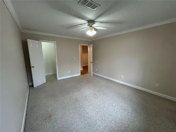 an empty room with a ceiling fan and bathroom