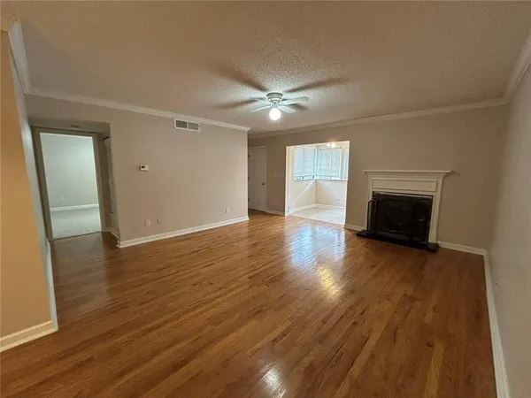 an empty room with wooden floor and fireplace