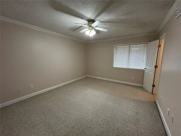an empty room with a ceiling fan and window