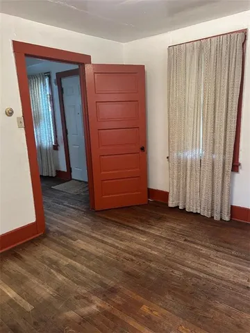 an empty room with wooden floor and a window