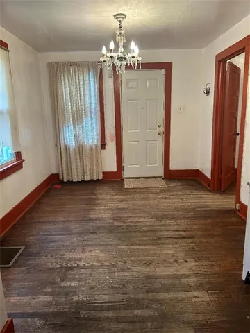 a view of a room with wooden floor and chandelier