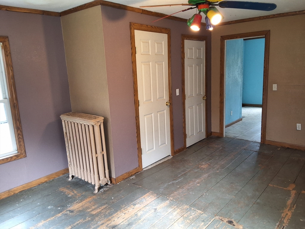72 Maple Street Warren, MA 01083 - Photo 14 of 16 an empty room with wooden floor and a ceiling fan