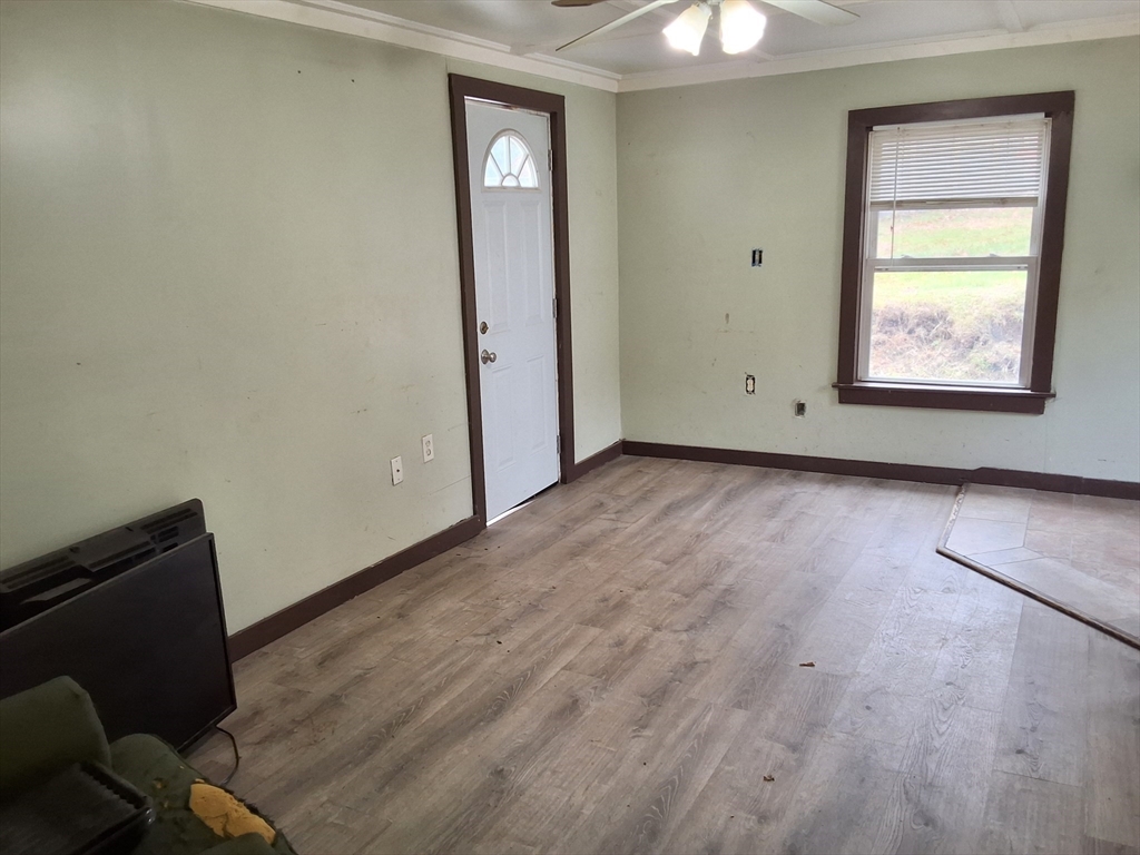 72 Maple Street Warren, MA 01083 - Photo 4 of 16 an empty room with wooden floor cabinet and windows