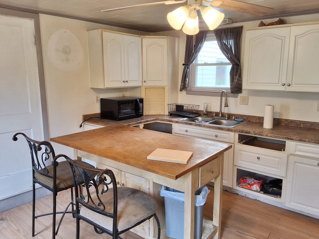 72 Maple Street Warren, MA 01083 - Photo 6 of 16 a kitchen with a stove a sink and a wooden cabinets