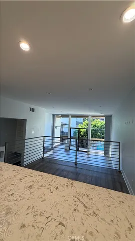a view of empty room with wooden floor and window