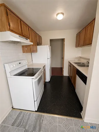 a kitchen with a stove sink and cabinets
