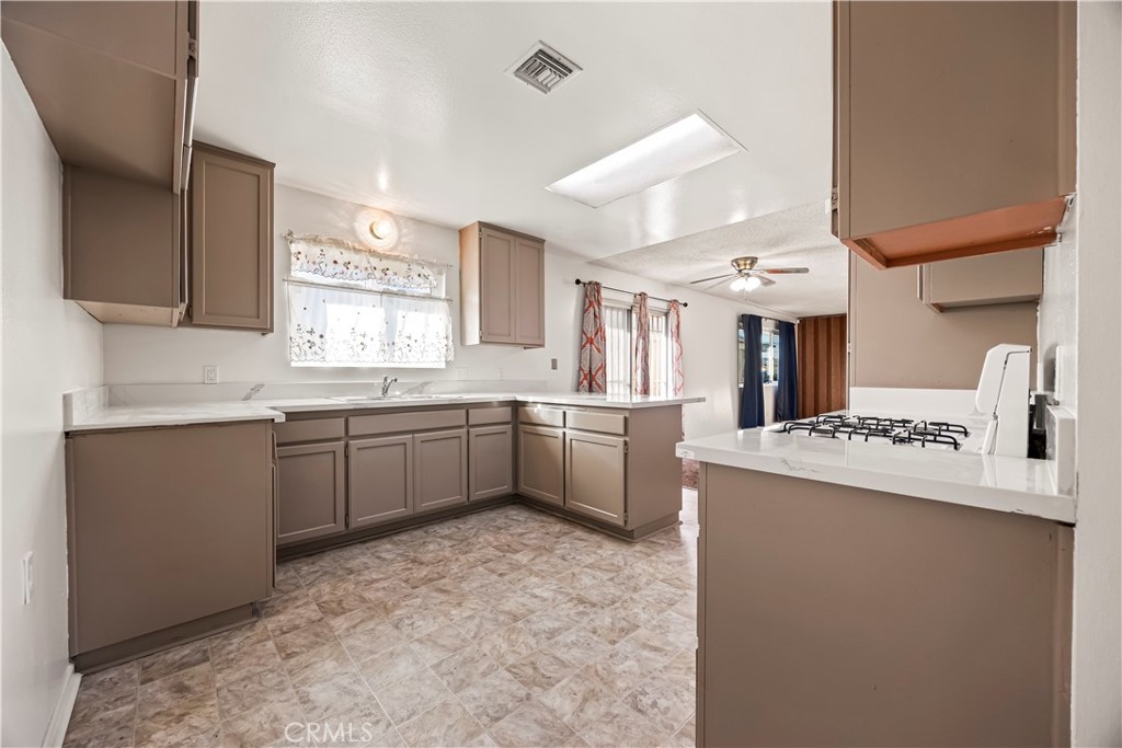 2520 14th Street Riverside, CA 92507 - Photo 5 of 17 a kitchen with a sink a stove a refrigerator cabinets and a window