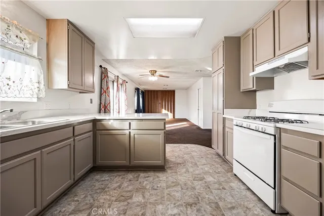 a kitchen with granite countertop a sink stove and cabinets