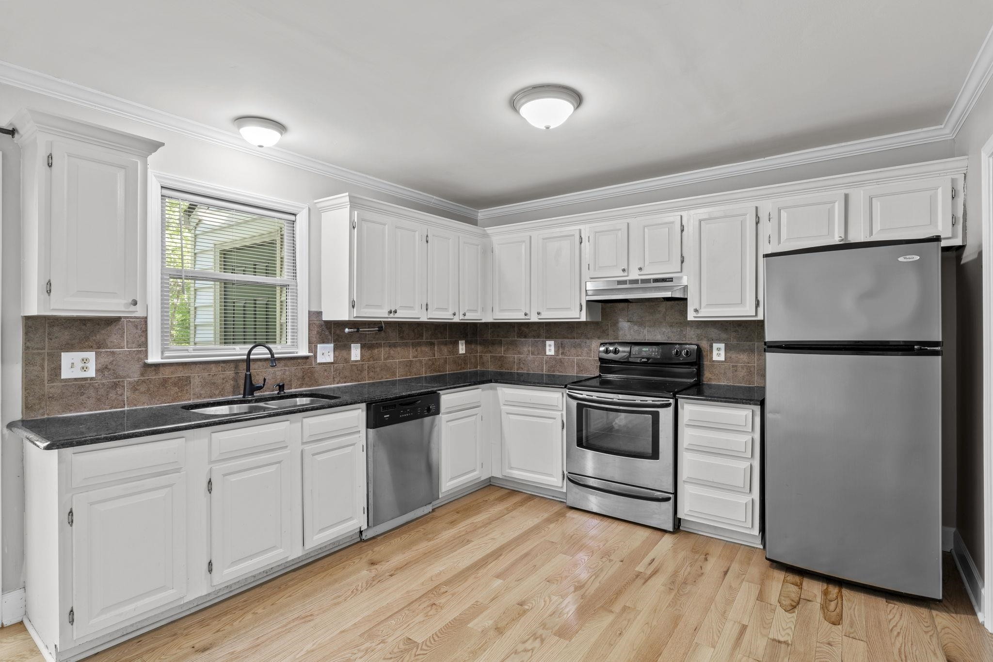 6506 Thetford Court Raleigh, NC 27615 - Photo 11 of 26 a kitchen with granite countertop white cabinets and white appliances