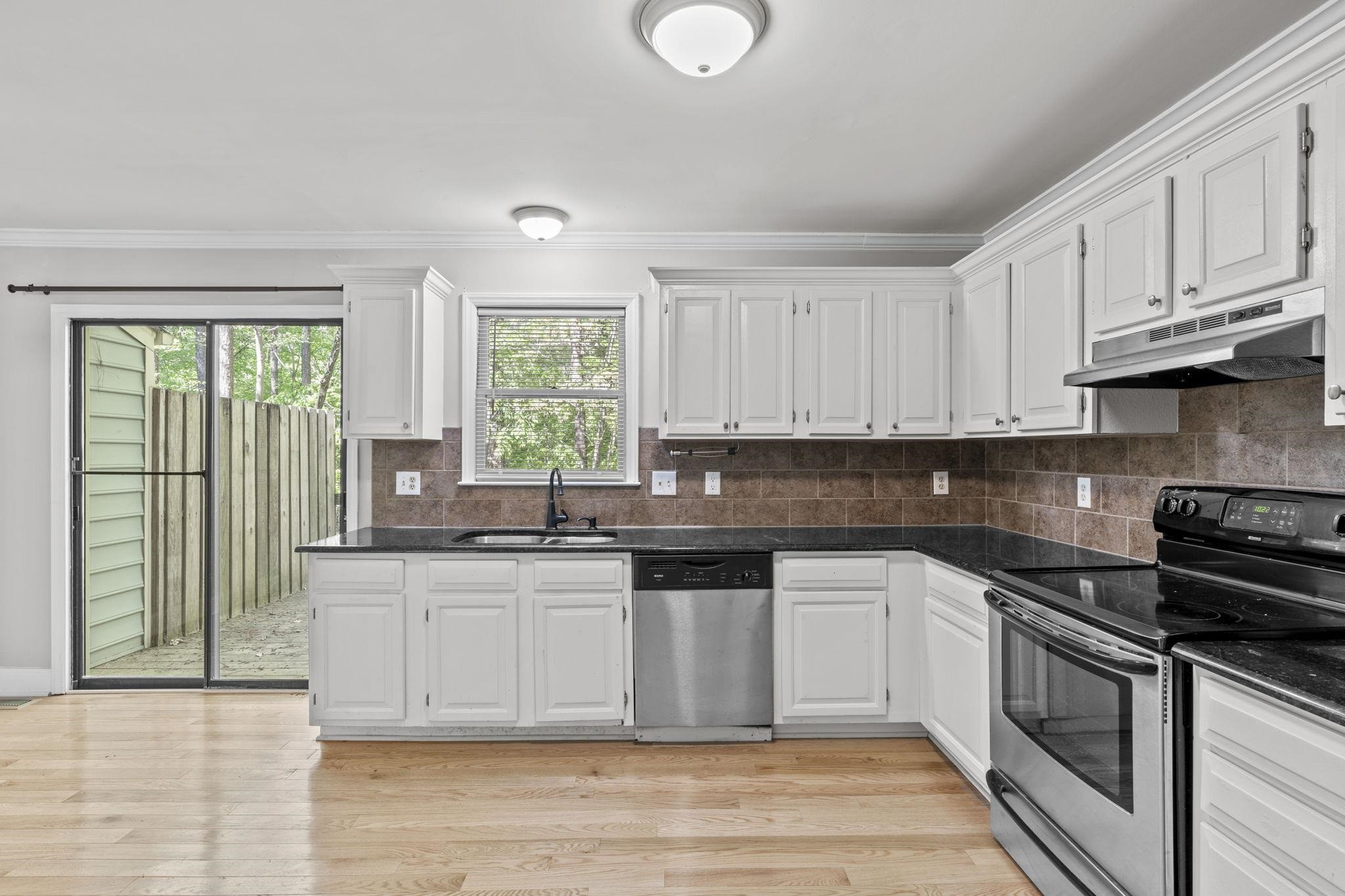 6506 Thetford Court Raleigh, NC 27615 - Photo 12 of 26 a kitchen with stainless steel appliances granite countertop a stove a sink and a white cabinets