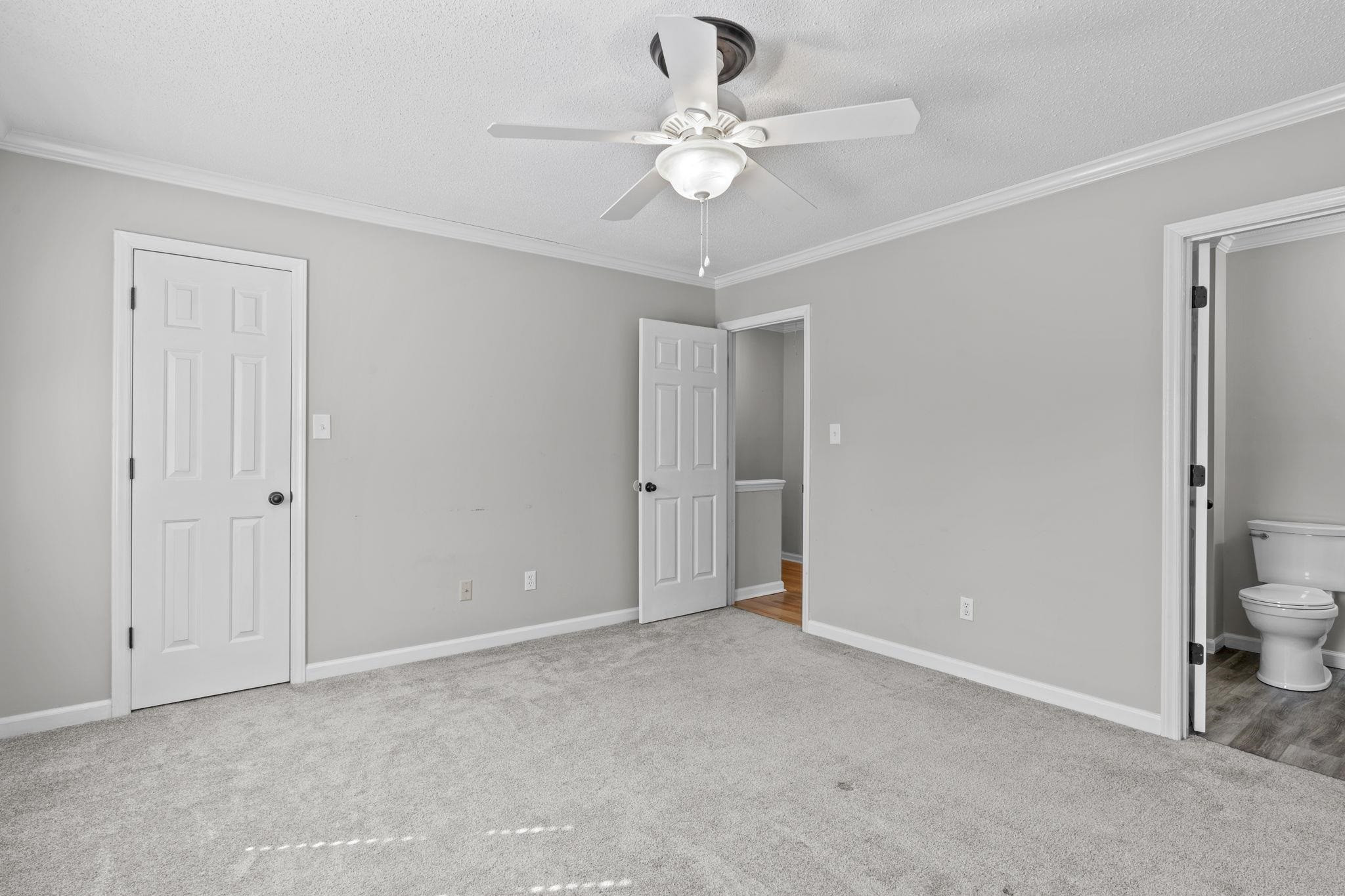 6506 Thetford Court Raleigh, NC 27615 - Photo 18 of 26 a view of a room with a ceiling fan and a bathroom