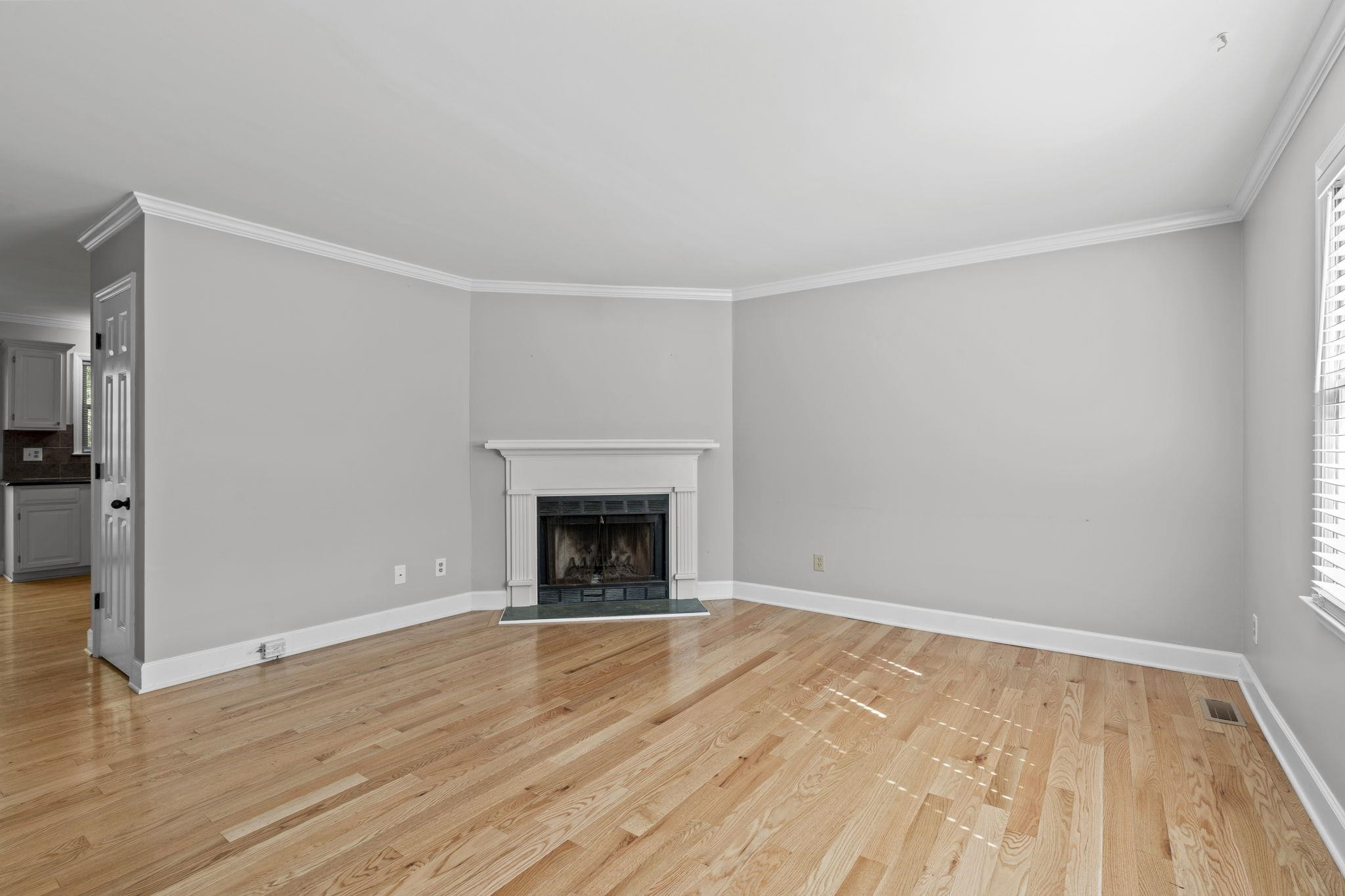 6506 Thetford Court Raleigh, NC 27615 - Photo 4 of 26 a view of empty room with wooden floor and fireplace