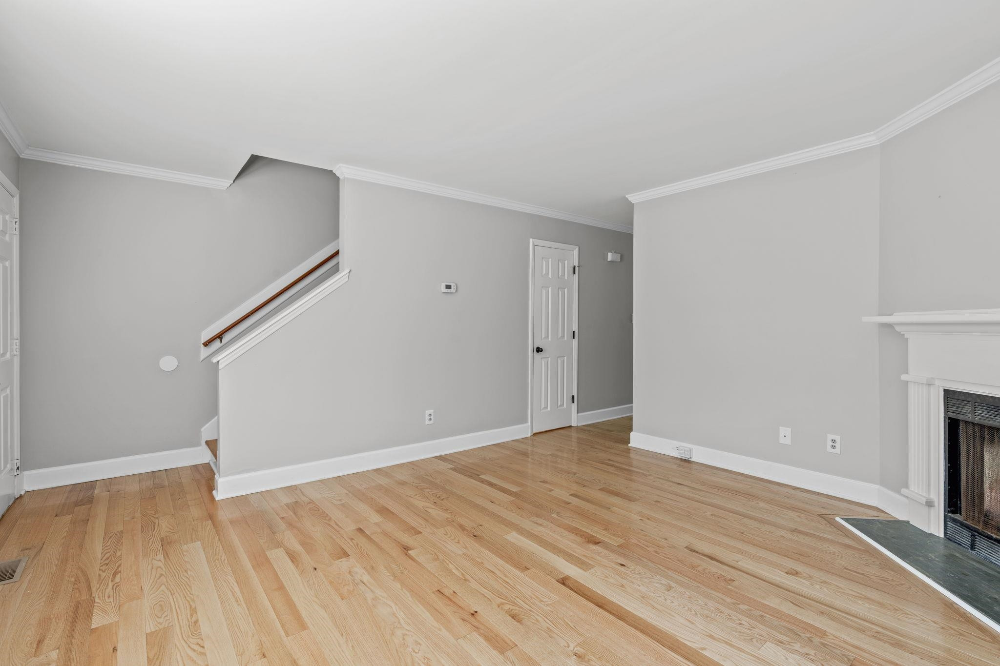 6506 Thetford Court Raleigh, NC 27615 - Photo 5 of 26 a view of an empty room with wooden floor and a fireplace