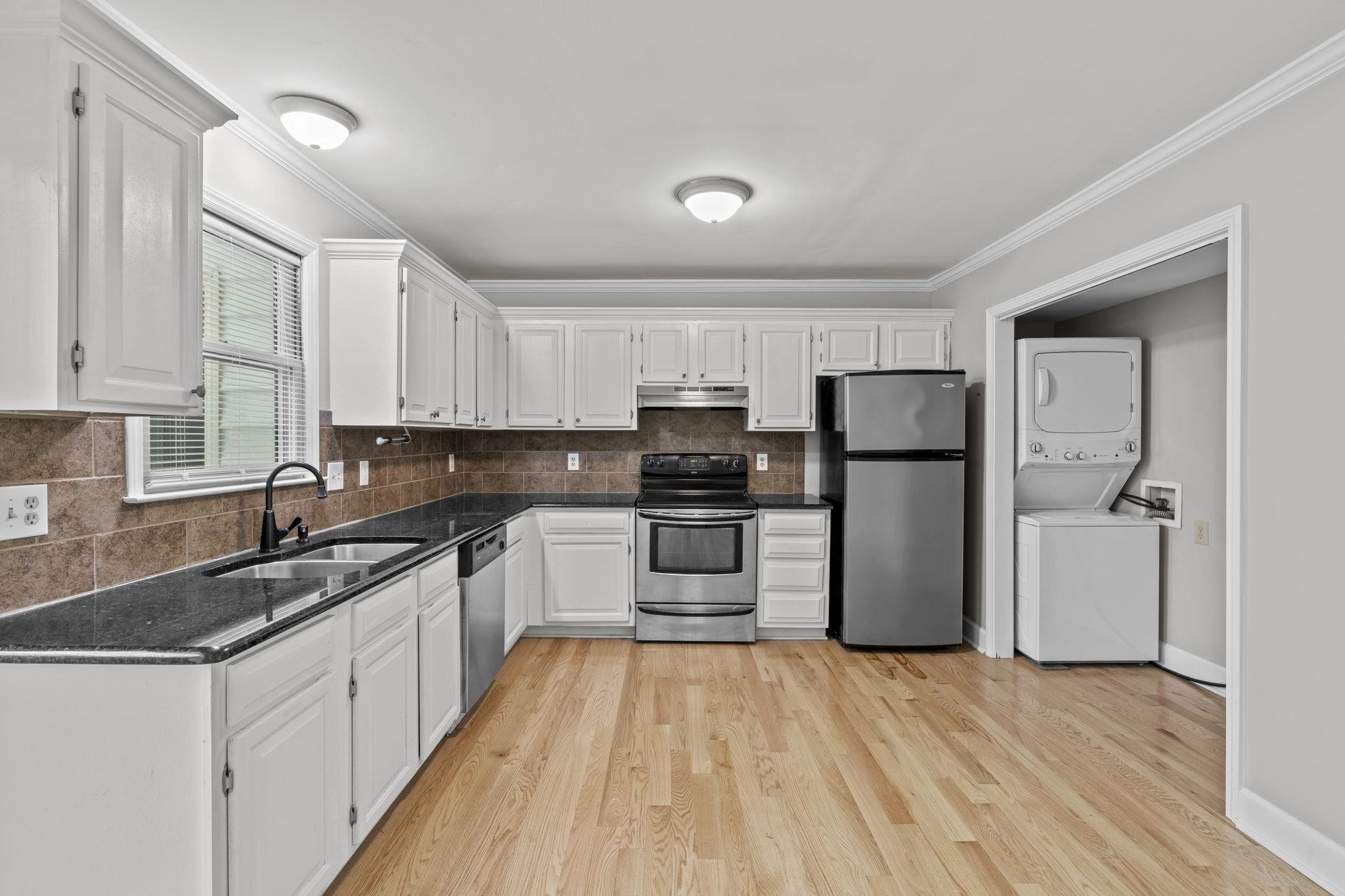 6506 Thetford Court Raleigh, NC 27615 - Photo 10 of 26 a kitchen with a refrigerator a sink and dishwasher with wooden floor