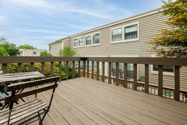 a view of a balcony with wooden floor and outdoor seating