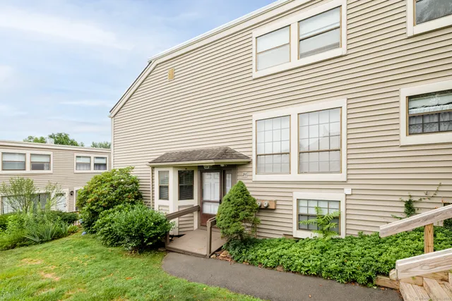 a view of a white house next to a yard