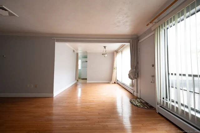 a view of a hallway with wooden floor and windows