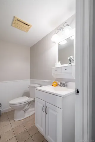 a bathroom with a sink a toilet and mirror