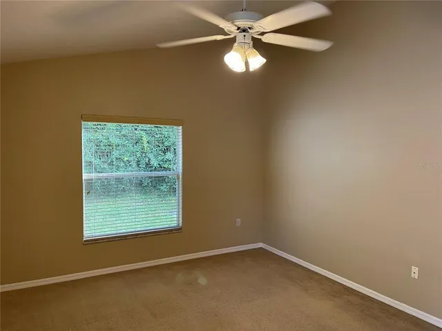 an empty room with a window and a fan