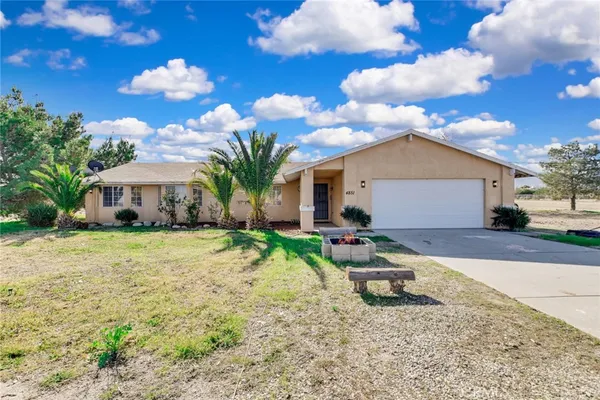 a house view with a sitting space fire pit and outdoor space