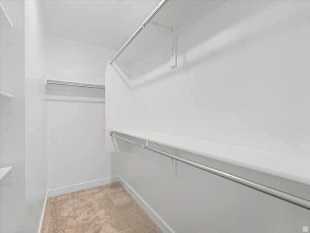 11759 South Watercourse Road South Jordan, UT 84009 - Photo 13 of 33 Spacious walk-in closet featuring light-toned carpeting and multiple built-in shelving and hanging rods
