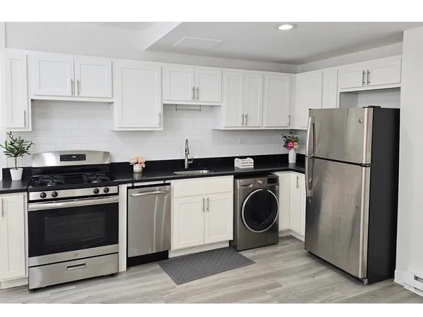 a kitchen with a stove top oven and refrigerator