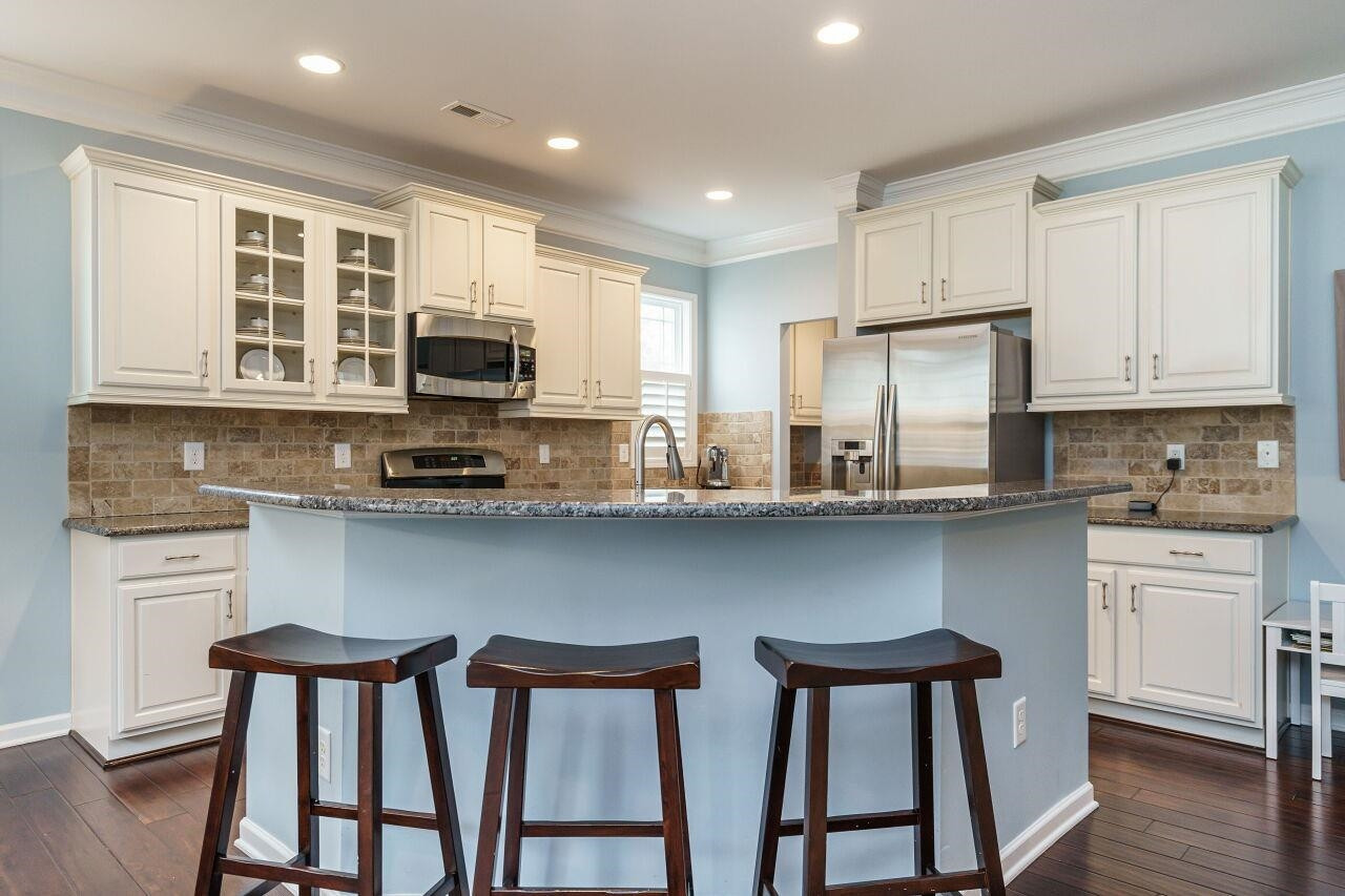 5602 Wade Park Boulevard Raleigh, NC 27607 - Photo 13 of 34 Upgraded cabinets, glass front cabinets, stainless appliances, five burner gas range, stone subway backsplash, granite and refrigerator included in this chef's kitchen! Kitchen