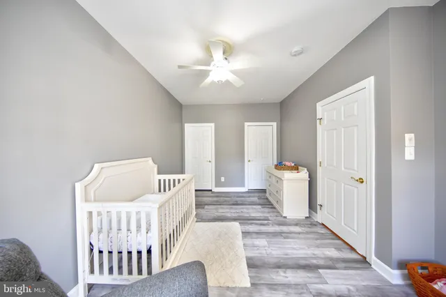 a view of a bedroom with wooden floor and windows