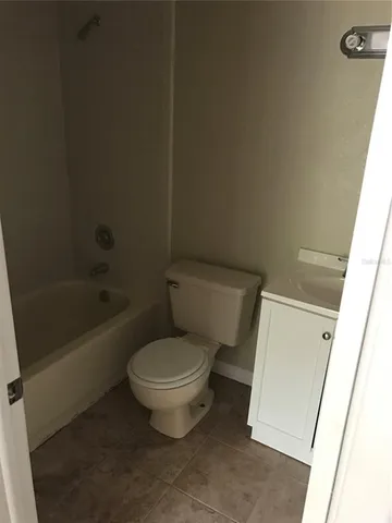 a white toilet sitting next to a bath tub