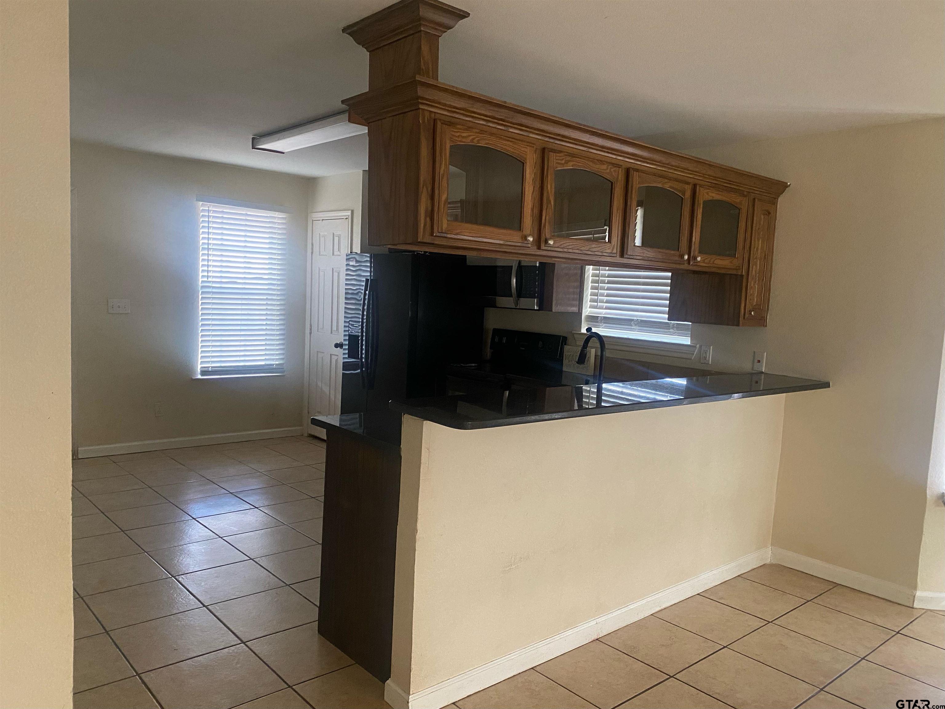 717 West Morris Street Tyler, TX 75702 - Photo 5 of 18 a kitchen with a refrigerator and a stove top oven