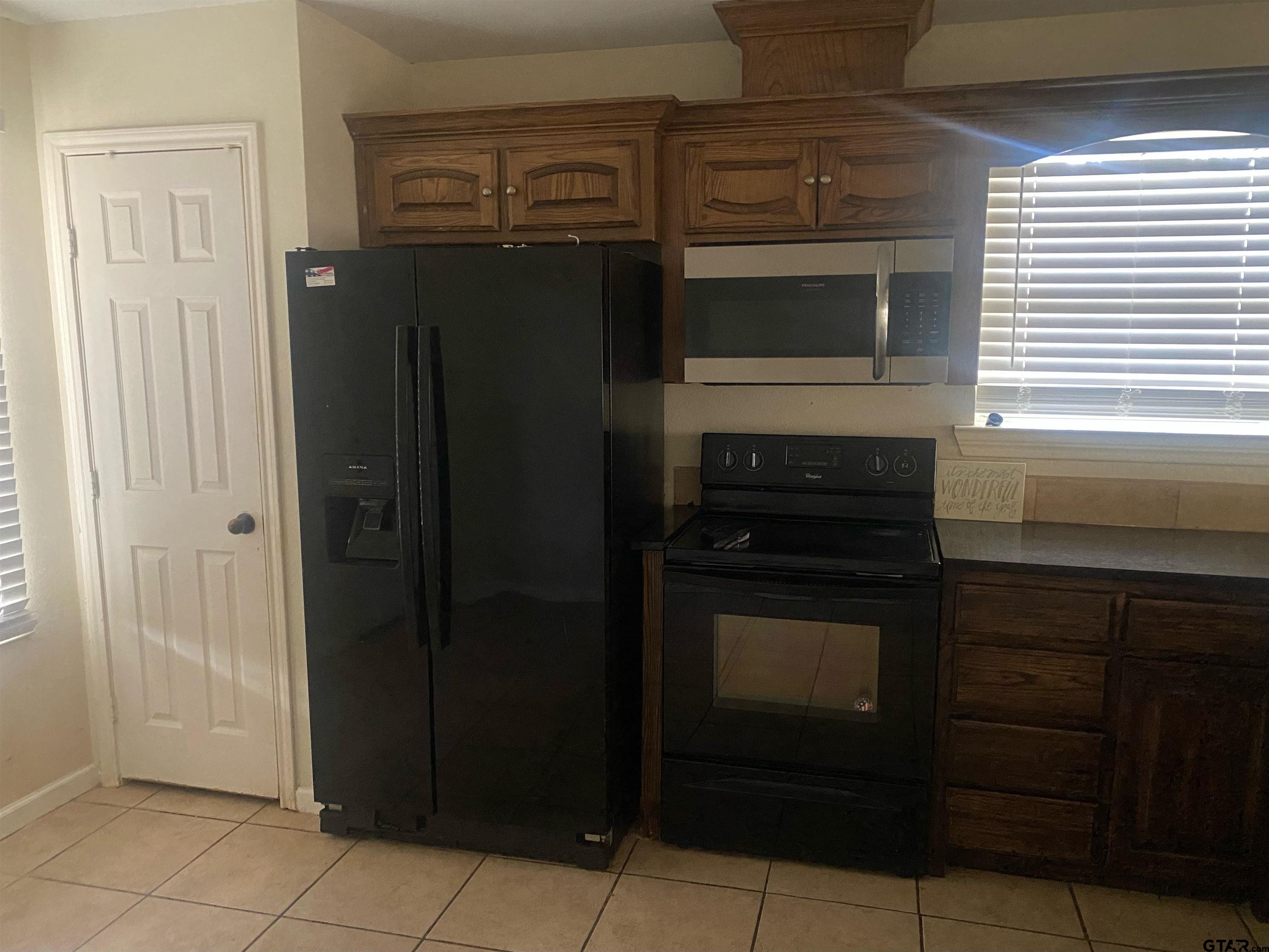 717 West Morris Street Tyler, TX 75702 - Photo 6 of 18 a kitchen with granite countertop a refrigerator and a stove
