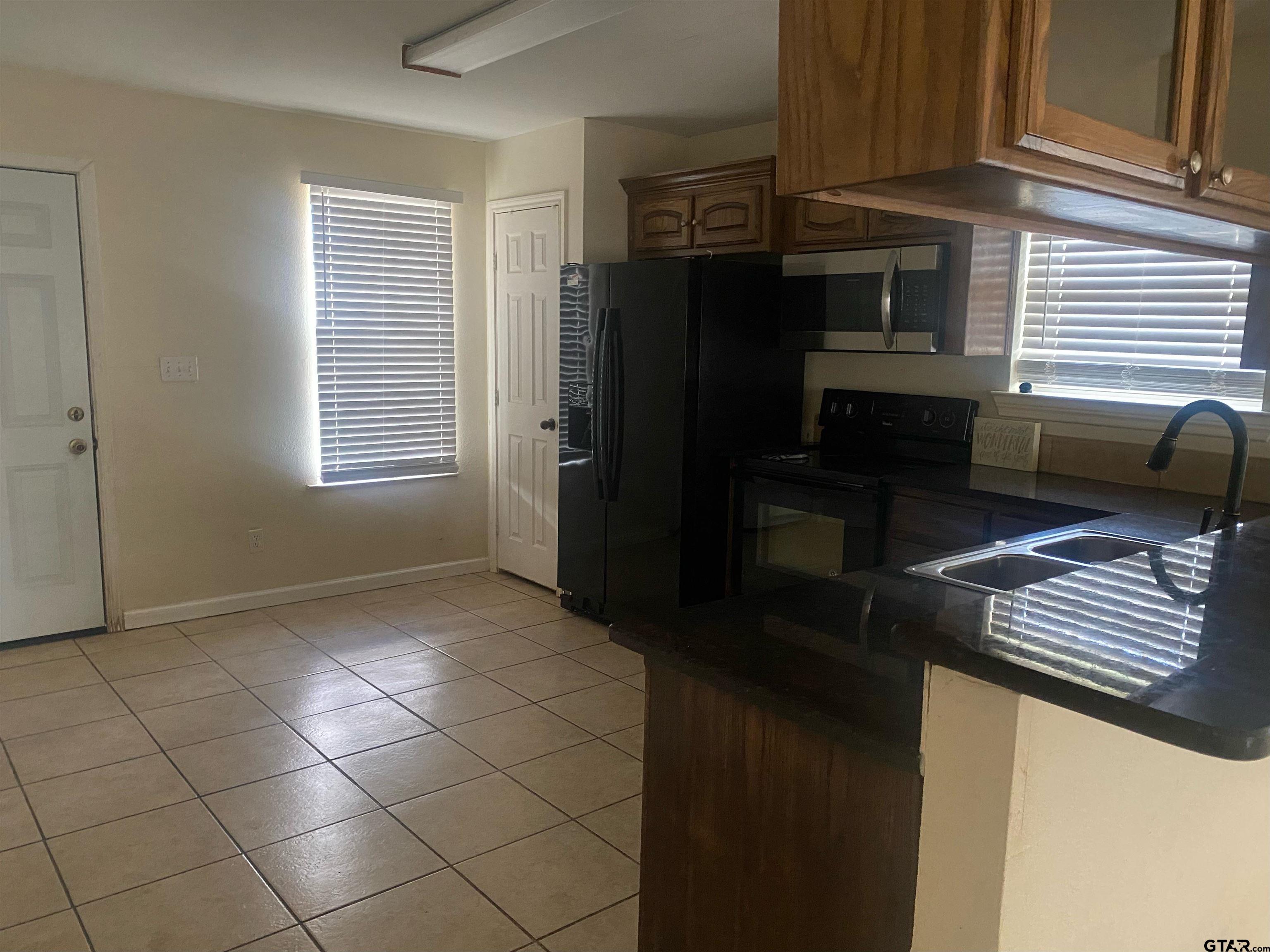 717 West Morris Street Tyler, TX 75702 - Photo 7 of 18 a kitchen with a refrigerator and a stove