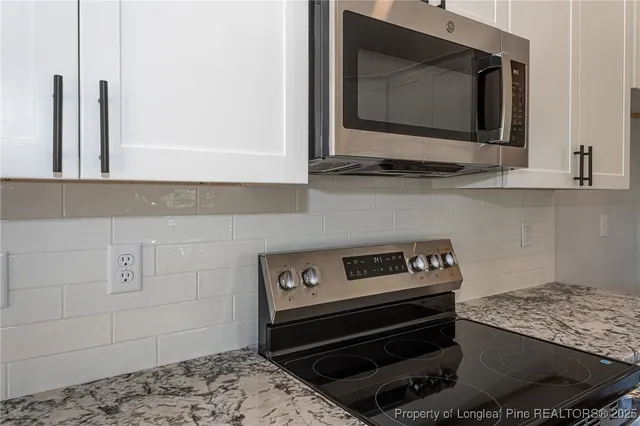 a living room with a stove and a microwave