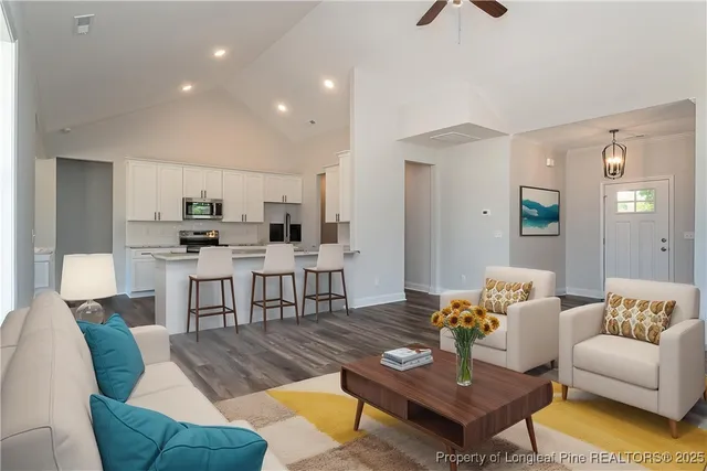 a living room with furniture and kitchen view