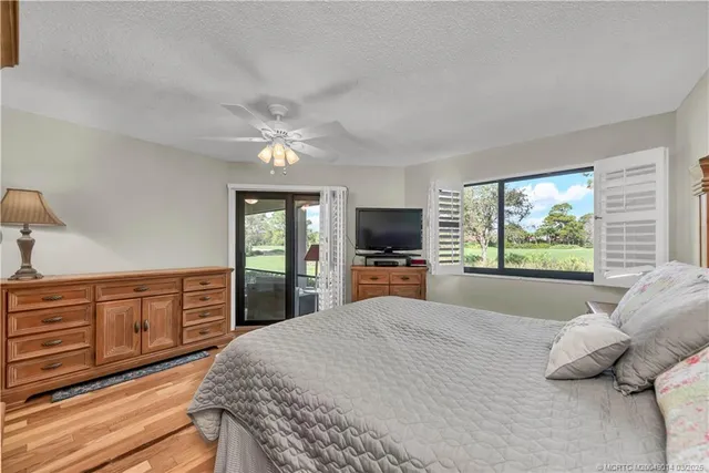 a large bedroom with a large bed and a flat tv screen on dresser