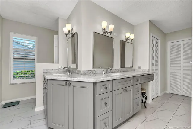 a bathroom with a granite countertop sink a large mirror and a shower