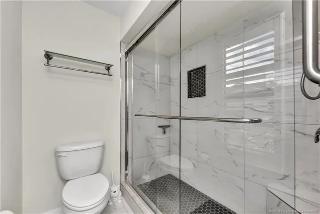 a bathroom with a toilet and a shower