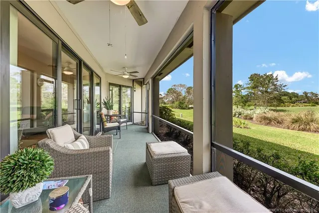 a view of a porch with furniture and floor to ceiling window