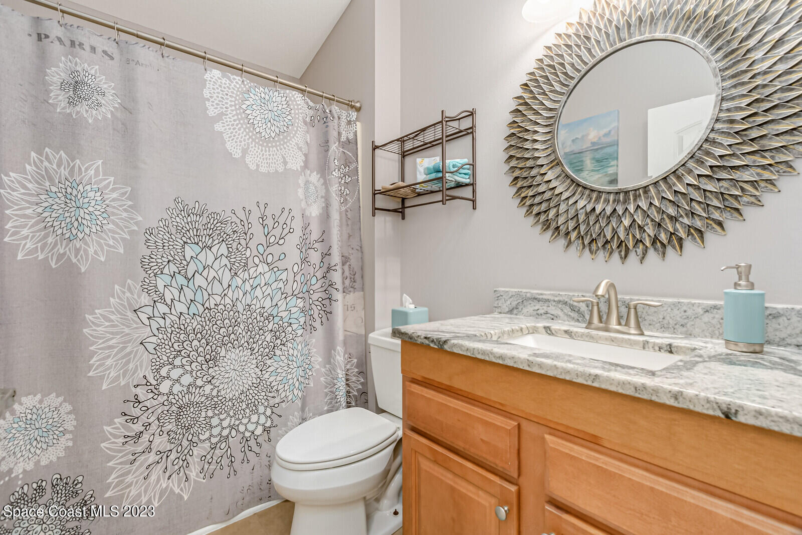 1569 Oconner Avenue Melbourne, FL 32940 - Photo 21 of 37 a bathroom with a granite countertop sink a mirror and a toilet