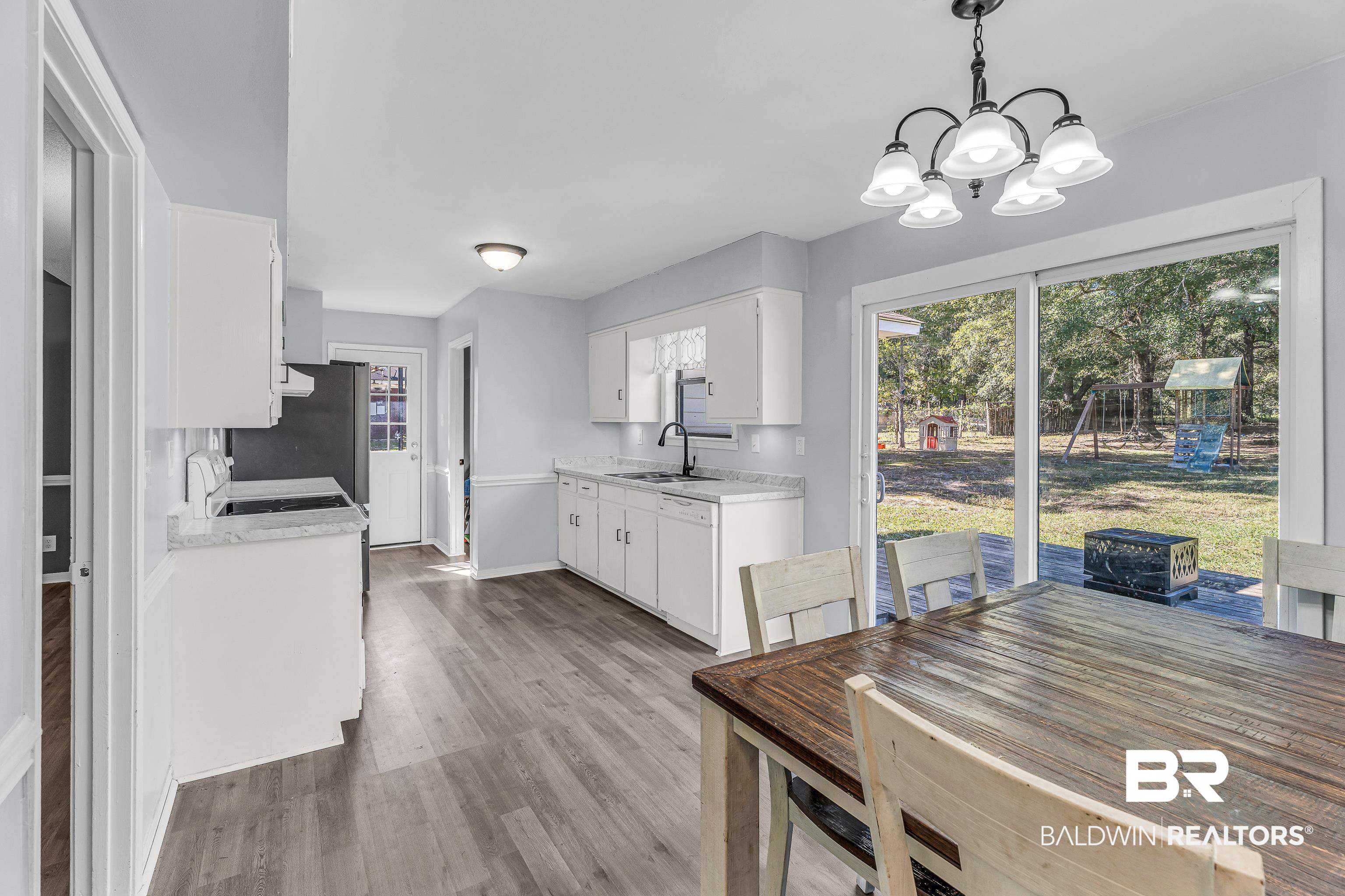 6135 Oak Cliff Drive Eight Mile, AL 36613 - Photo 10 of 30 Dining space featuring healthy amount of natural light, light wood-type flooring, and a chandelier