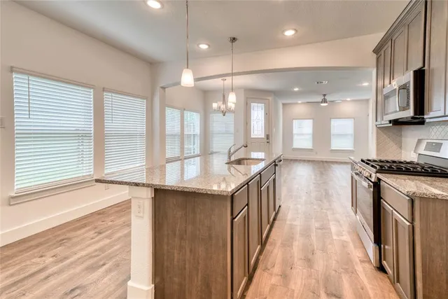 a kitchen with stainless steel appliances granite countertop a stove and a sink